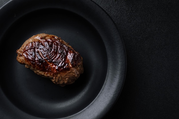 Close-up of a grilled steak served on a dark plate